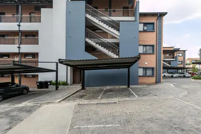 an empty parking lot in front of a building at Modern 2 bed apartment, Secure estate in Midrand