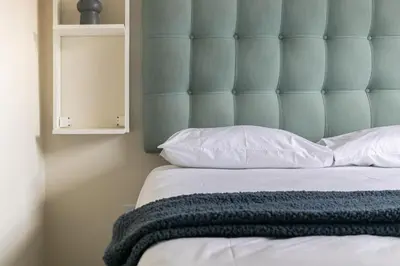 a bed with a blue headboard and white pillows at Modern 2 bed apartment, Secure estate in Midrand