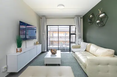 a living room with a white couch and a tv at Modern 2 bed apartment, Secure estate in Midrand