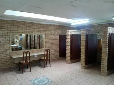 a bathroom with two chairs and a sink and a mirror at Sabie River Camp in Sabie