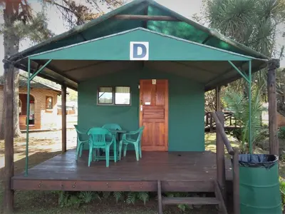 a house with a table and chairs on a deck at Sabie River Camp in Sabie