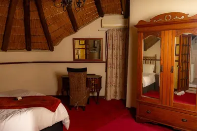 a bedroom with a bed and a dresser and a mirror at Manor House at Harties Lodge - Meerhof in Hartbeespoort