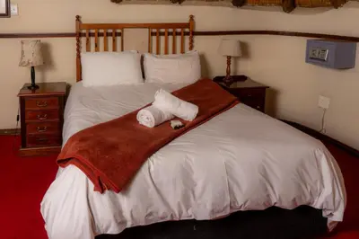 a bedroom with a bed with two towels on it at Manor House at Harties Lodge - Meerhof in Hartbeespoort