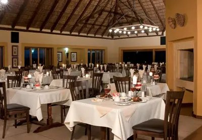 a banquet hall with tables and chairs with white table cloth at Hannah Game Lodge in Ohrigstad