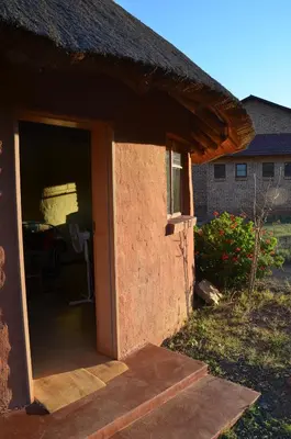 an entrance to a house with a thatch roof at Bama Lodge in Ohrigstad