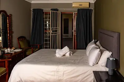 a bedroom with a large bed with white sheets and pillows at Harties Lodge - Bay View 5 in Hartbeespoort