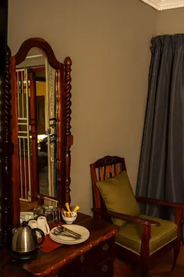 a room with a table and a mirror and a chair at Harties Lodge - Bay View 5 in Hartbeespoort
