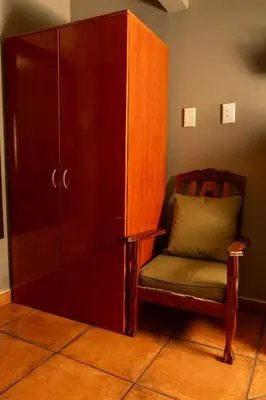 a chair sitting next to a cabinet in a room at Harties Lodge - Bay View 5 in Hartbeespoort