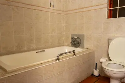 a bathroom with a bath tub and a toilet at Harties Lodge - Bay View 5 in Hartbeespoort