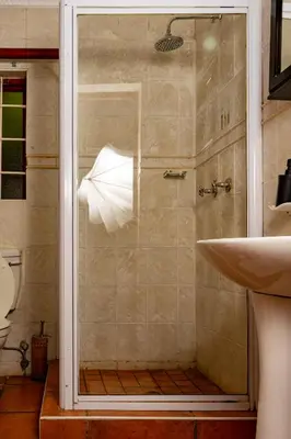 a shower with a glass door next to a sink at Harties Lodge - Bay View 5 in Hartbeespoort