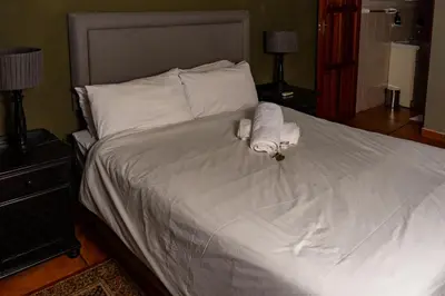 a bed with two rolled up towels on it at Harties Lodge - Bay View 4 in Hartbeespoort