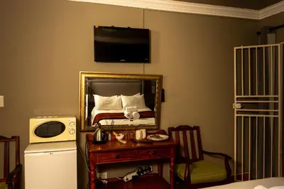 a bedroom with a bed with a tv on the wall at Harties Lodge - Bay View 4 in Hartbeespoort