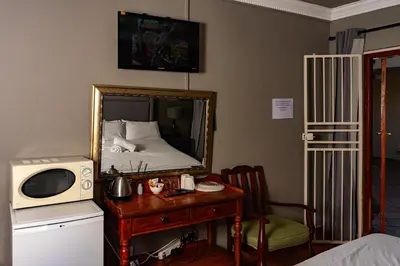 a bedroom with a mirror and a table with a microwave at Harties Lodge - Bay View 4 in Hartbeespoort