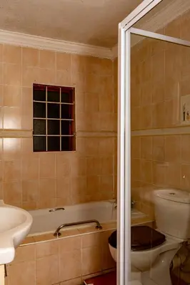 a bathroom with a tub and a toilet and a sink at Harties Lodge - Bay View 4 in Hartbeespoort