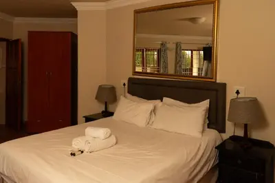 a bedroom with a bed with a towel on it at Harties Lodge - Meerhof Bay View 6 in Hartbeespoort