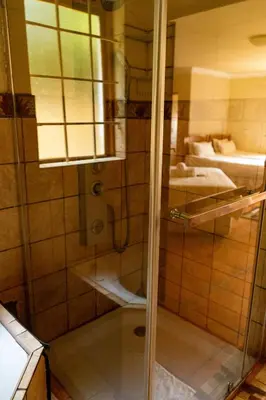 a bathroom with a shower with a glass door at Harties Lodge - Meerhof Bay View 6 in Hartbeespoort