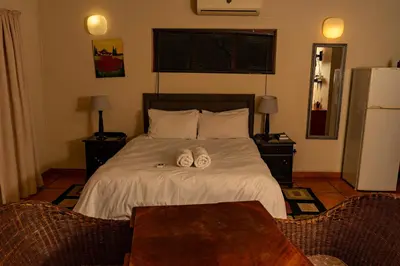 a bedroom with a bed with two slippers on it at Harties Lodge - Meerhof Bay View 7 Family Room in Hartbeespoort