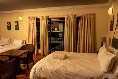 a hotel room with two beds and a table with a table at Harties Lodge - Meerhof Bay View 7 Family Room in Hartbeespoort
