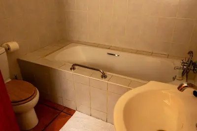 a bathroom with a tub and a toilet and a sink at Harties Lodge - Meerhof Bay View 7 Family Room in Hartbeespoort