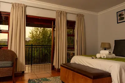 a bedroom with a bed and a balcony at Harties Lodge - Meerhof Bay View 8 in Hartbeespoort