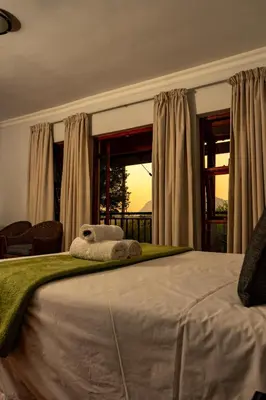 a bedroom with a large bed and a window at Harties Lodge - Meerhof Bay View 8 in Hartbeespoort