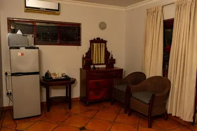 a kitchen with a refrigerator and a table and chairs at Harties Lodge - Meerhof Bay View 8 in Hartbeespoort