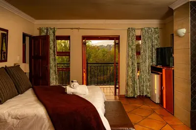 a bedroom with a bed and a view of a balcony at Bay View 9 at Harties Lodge - Meerhof in Hartbeespoort