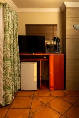 a room with a desk with a microwave and a television at Bay View 9 at Harties Lodge - Meerhof in Hartbeespoort