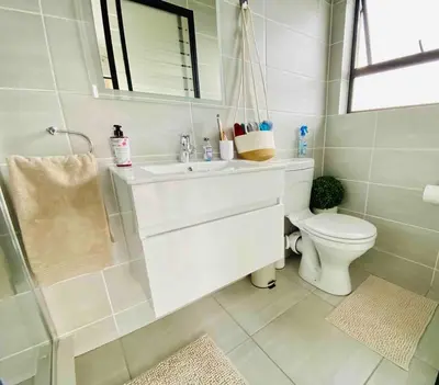 a bathroom with a sink and a toilet and a mirror at 1 Bed in Waterfall - Book 4 & Get 5th Night FREE in Midrand