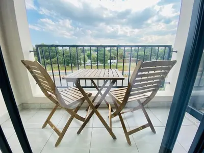 a wooden table and two chairs on a balcony at 1 Bed in Waterfall - Book 4 & Get 5th Night FREE in Midrand