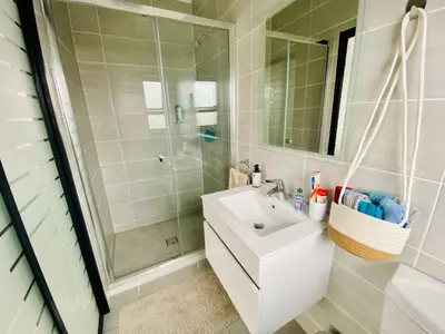 a bathroom with a white sink and a shower at 1 Bed in Waterfall - Book 4 & Get 5th Night FREE in Midrand
