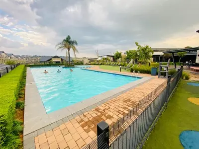an image of a swimming pool with people in it at 1 Bed in Waterfall - Book 4 & Get 5th Night FREE in Midrand