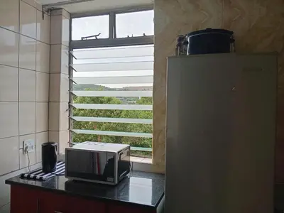 a microwave on a counter in a kitchen with a window at Modern style Apartment in Pretoria-Central in Pretoria
