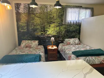 a room with two beds and a window at Green Cottage in Haenertsburg