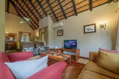 a living room with a couch and a tv at Kruger Park Lodge Unit No. 524 in Hazyview