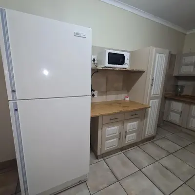 a kitchen with a white refrigerator and a microwave at Capital Hill Stay at Spa in Pretoria
