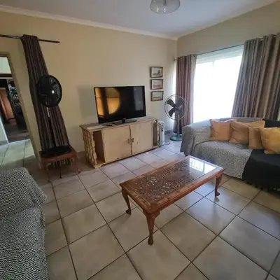 a living room with a couch and a tv at Capital Hill Stay at Spa in Pretoria