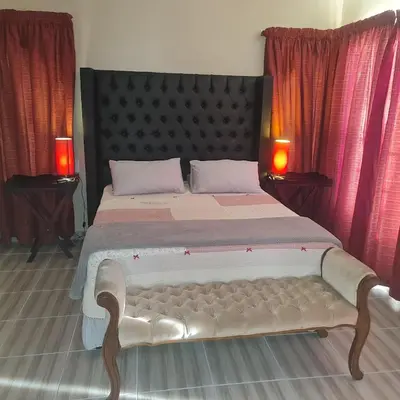 a bedroom with a large bed with two lamps at Capital Hill Stay at Spa in Pretoria