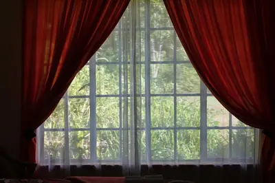 a window with red curtains in a room at Ekukhanyeni, The Place of Light in Boschjeskop