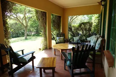 a patio with a table and chairs and a large window at Ekukhanyeni, The Place of Light in Boschjeskop