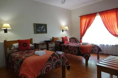 a hotel room with two beds and a window at Ekukhanyeni, The Place of Light in Boschjeskop