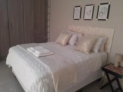 a bedroom with a white bed with towels on it at Bonfai Residence in Ermelo