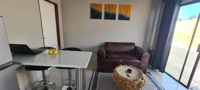 a living room with a table and a chair at Bonfai Residence in Ermelo