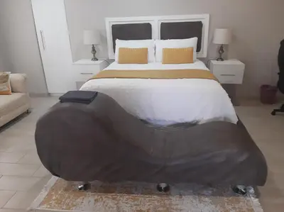 a bedroom with a large bed with a large headboard at Bonfai Residence in Ermelo