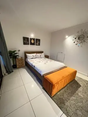 a bedroom with a king sized bed and a clock on the wall at Petalsoft in Pretoria