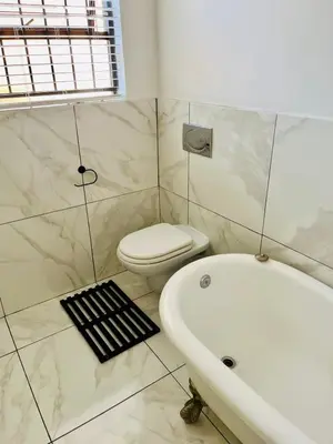 a bathroom with a tub and a toilet and a sink at Petalsoft in Pretoria