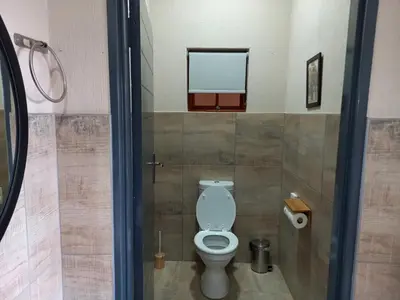 a bathroom with a white toilet in a stall at Tembo Guest Lodge in Hazyview