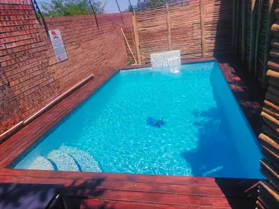 a swimming pool with a person in the water at Tembo Guest Lodge in Hazyview