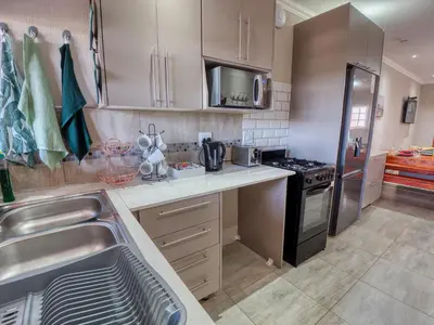 a kitchen with a sink and a stainless steel refrigerator at Tembo Guest Lodge in Hazyview