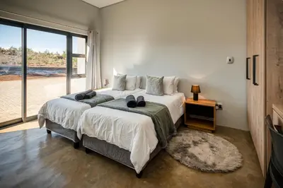 a bedroom with a large bed and a large window at Highland Gate Golf and Trout Estate 857 in Dullstroom